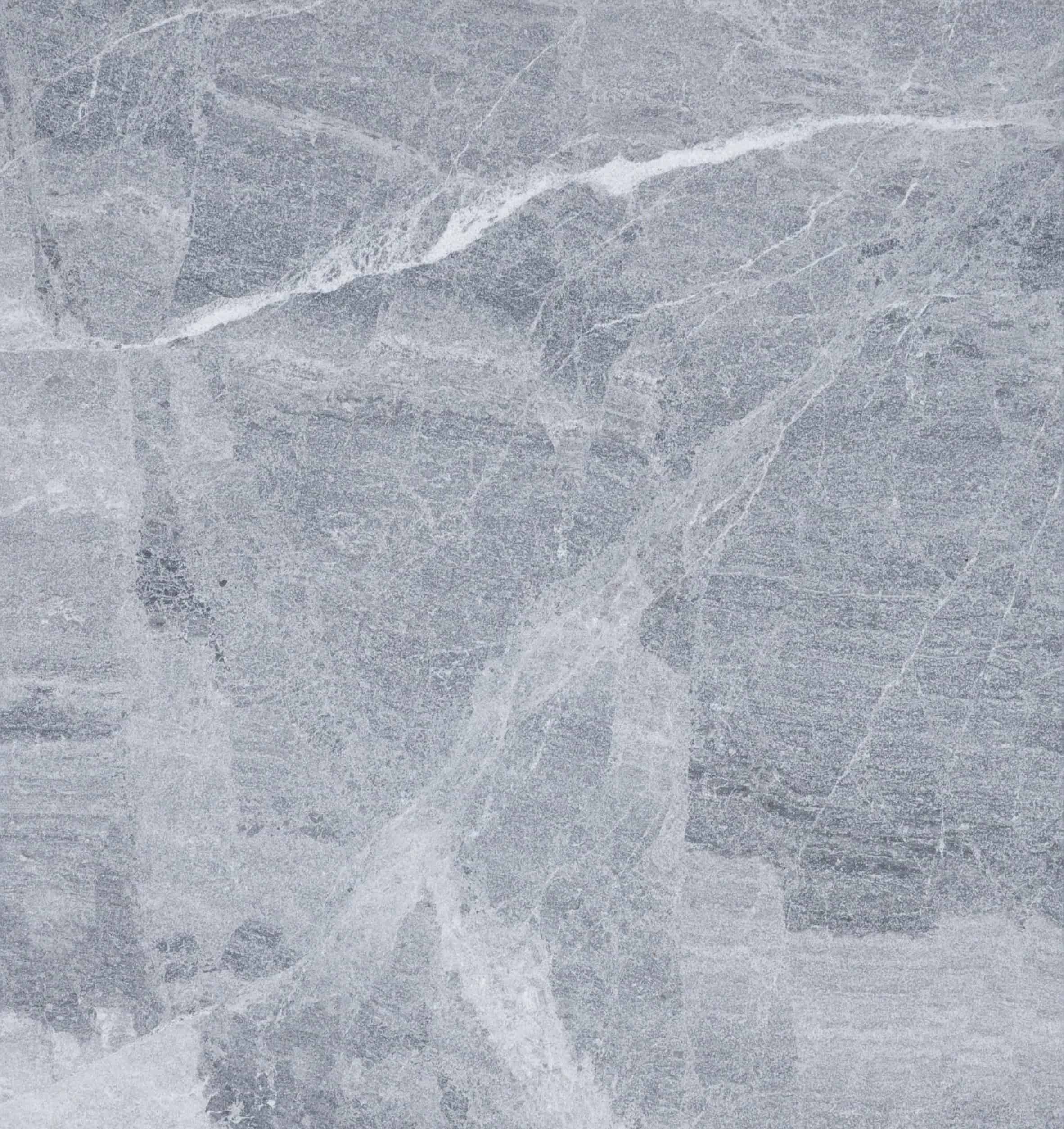Gray stone surface with subtle white veining and textured patterns throughout, resembling natural marble or granite, similar to the elegant look of Aegean Grey Marble.
