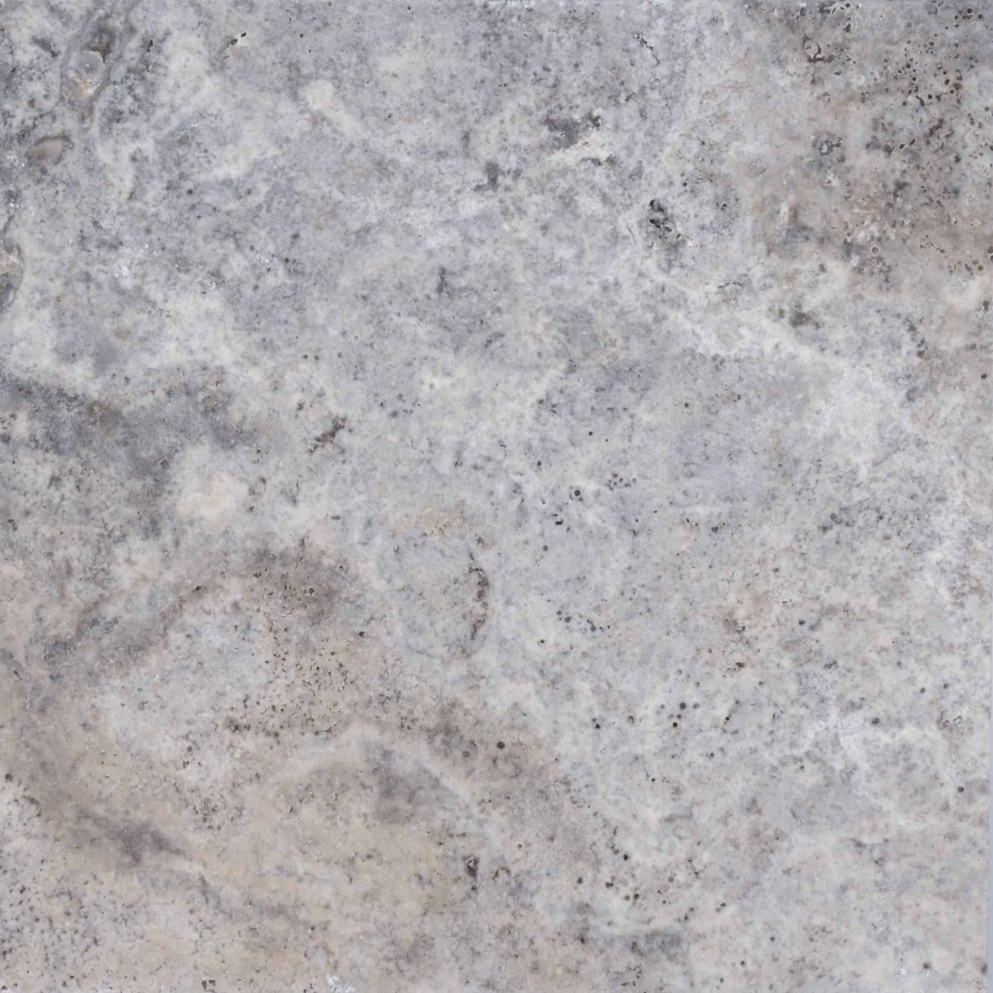 A close-up of a textured, gray stone surface with subtle variations in color, including light and dark gray areas, mottled patterns, and small specks throughout.