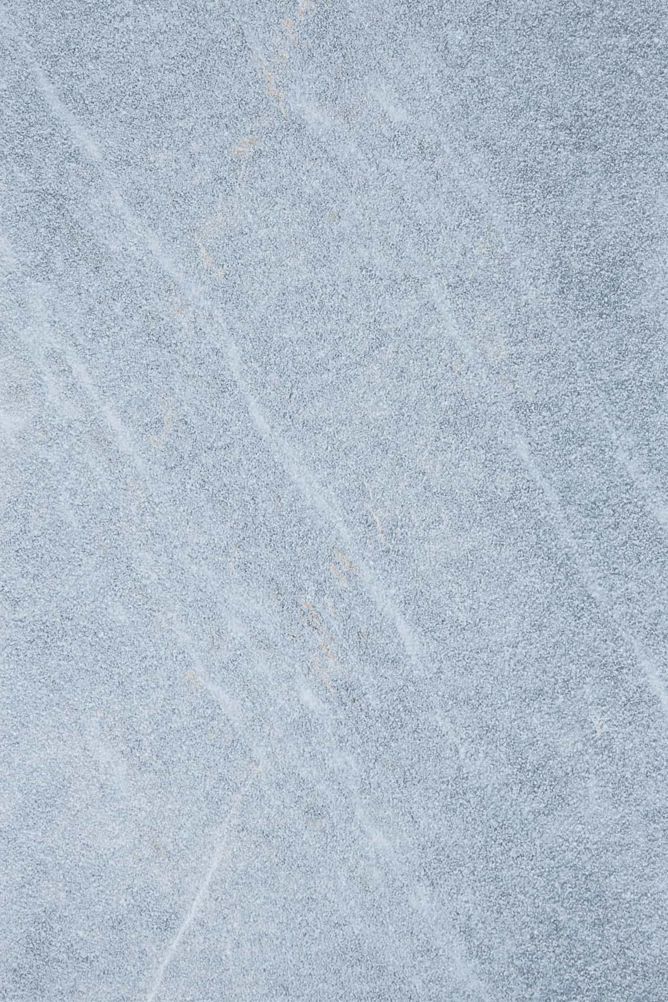 Close-up of Stonelux's Arctic Grey Marble Sand Blasted 16x24 3cm Paver. The natural stone features a light grey hue with subtle veining and a textured sandblasted finish, ideal for enhancing outdoor spaces with a modern, elegant look.