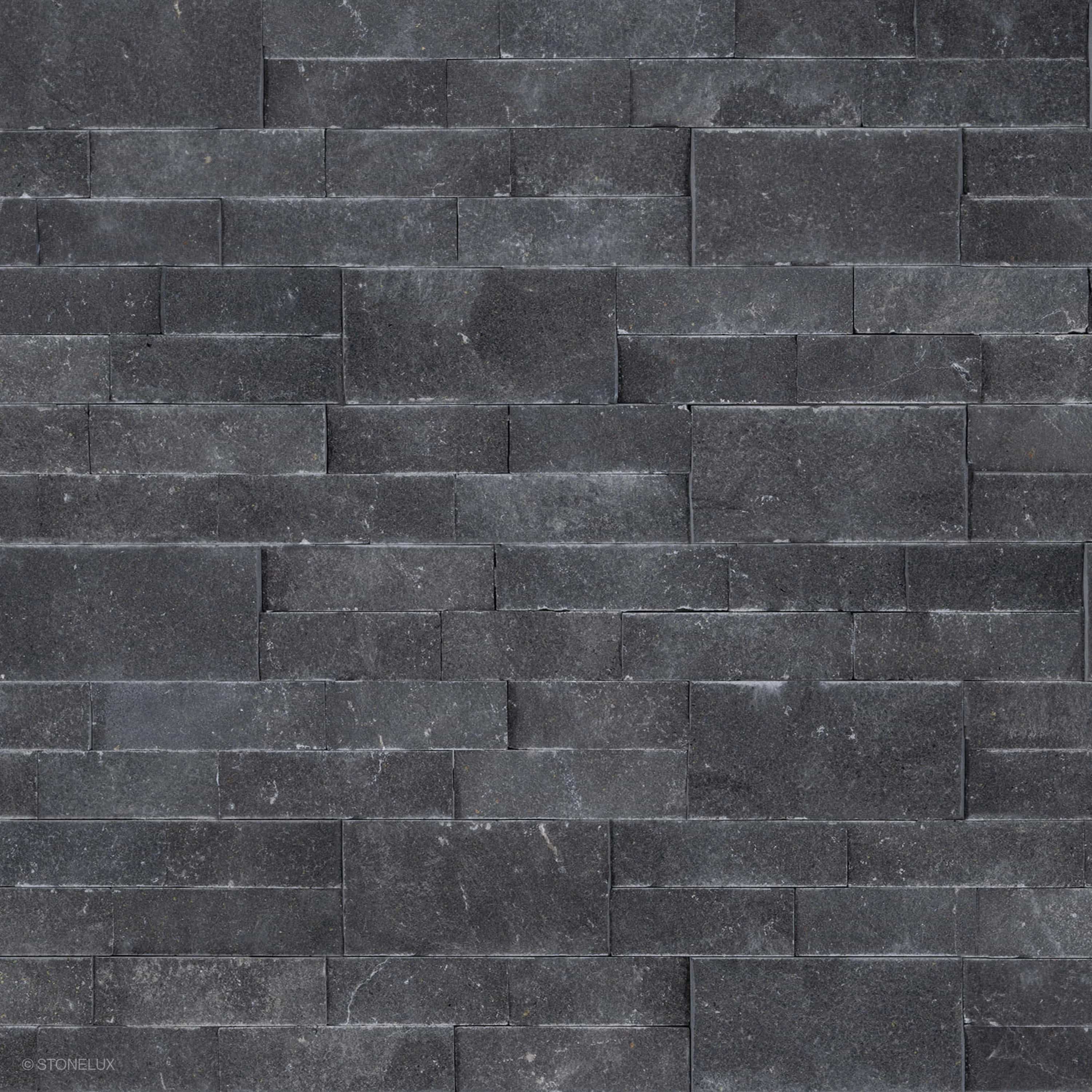 Close-up view of Black Basalt Splitface Ledger Panel - 6x24 by STONELUX, showcasing the natural basalt texture with rich dark tones and a rugged, splitface finish. Ideal for wall veneers, offering a sophisticated, modern aesthetic for hardscape projects.