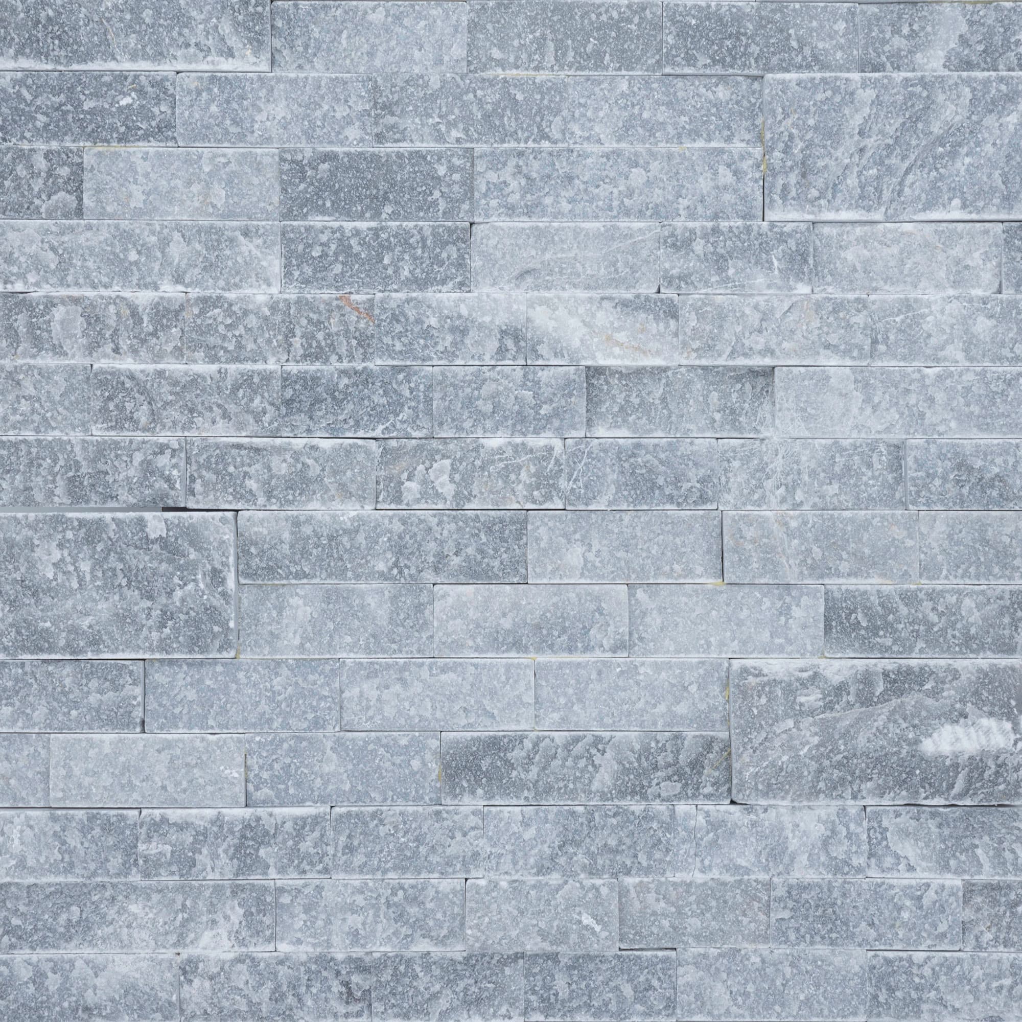 Close-up image of Afyon Grey Marble Splitface Ledger Panel in 6x24 size. The textured marble shows cool grey movement for wall veneer, outdoor living walls, pool features, and architectural cladding.