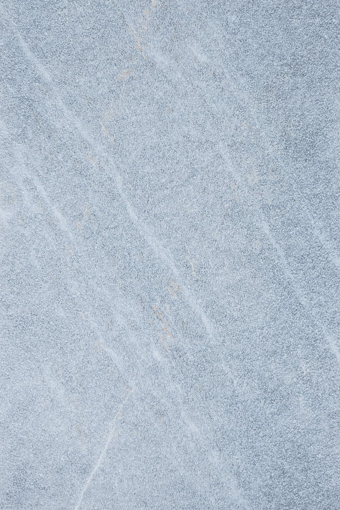 Close-up of Stonelux's Arctic Grey Marble Sand Blasted 16x24 3cm Paver. The natural stone features a light grey hue with subtle veining and a textured sandblasted finish, ideal for enhancing outdoor spaces with a modern, elegant look.