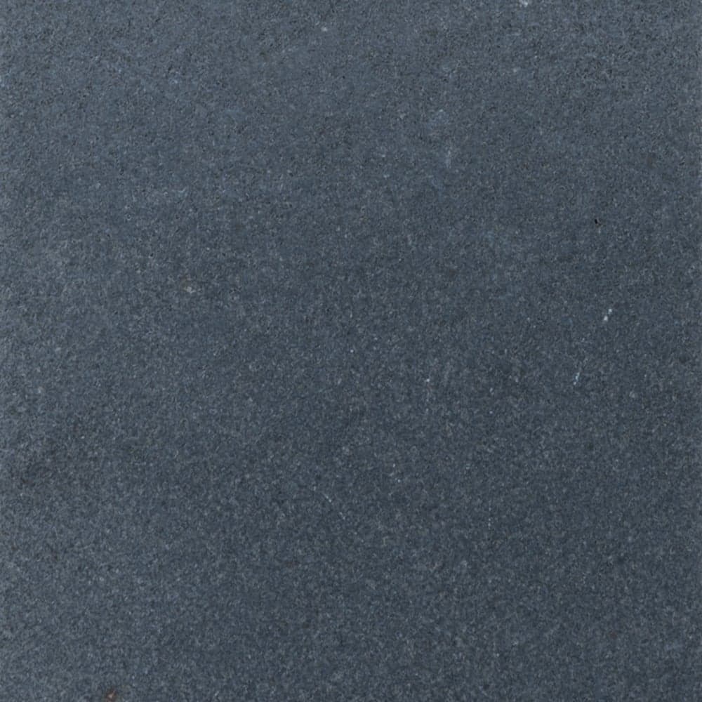 Close-up view of a dark gray, textured stone surface of Black Basalt, with a slightly rough and matte appearance. Subtle variations in color and small specks are scattered throughout.