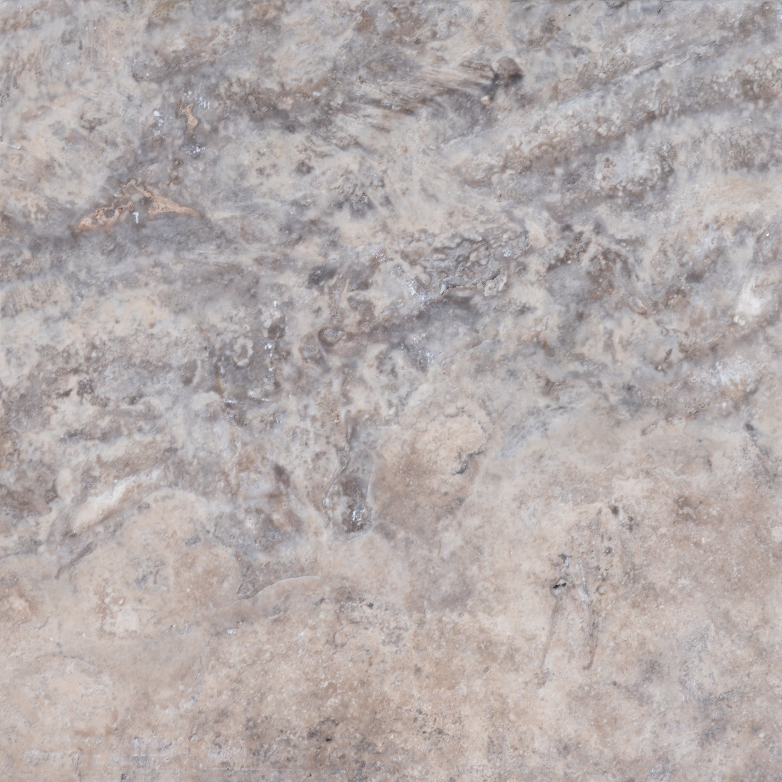 Close-up of Stonelux Silver Travertine natural stone showcasing its intricate texture and color variations. The stone features a blend of light grey and beige tones with subtle veining, ideal for luxurious hardscape projects and pool coping.