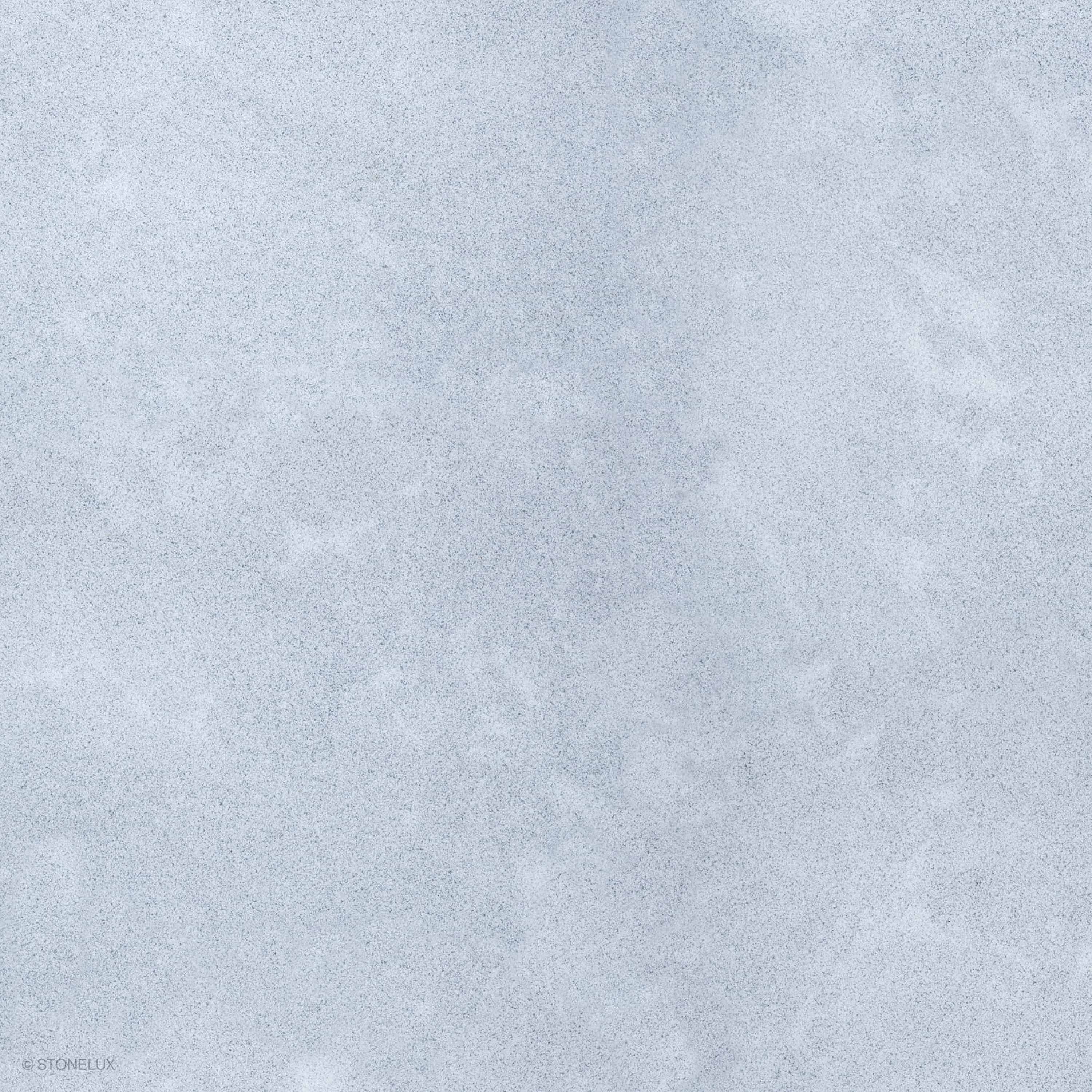 Close-up of Afyon Grey Marble showing a light cool-grey background, fine blue-grey speckling, soft cloudy movement, and a matte sandblasted surface.