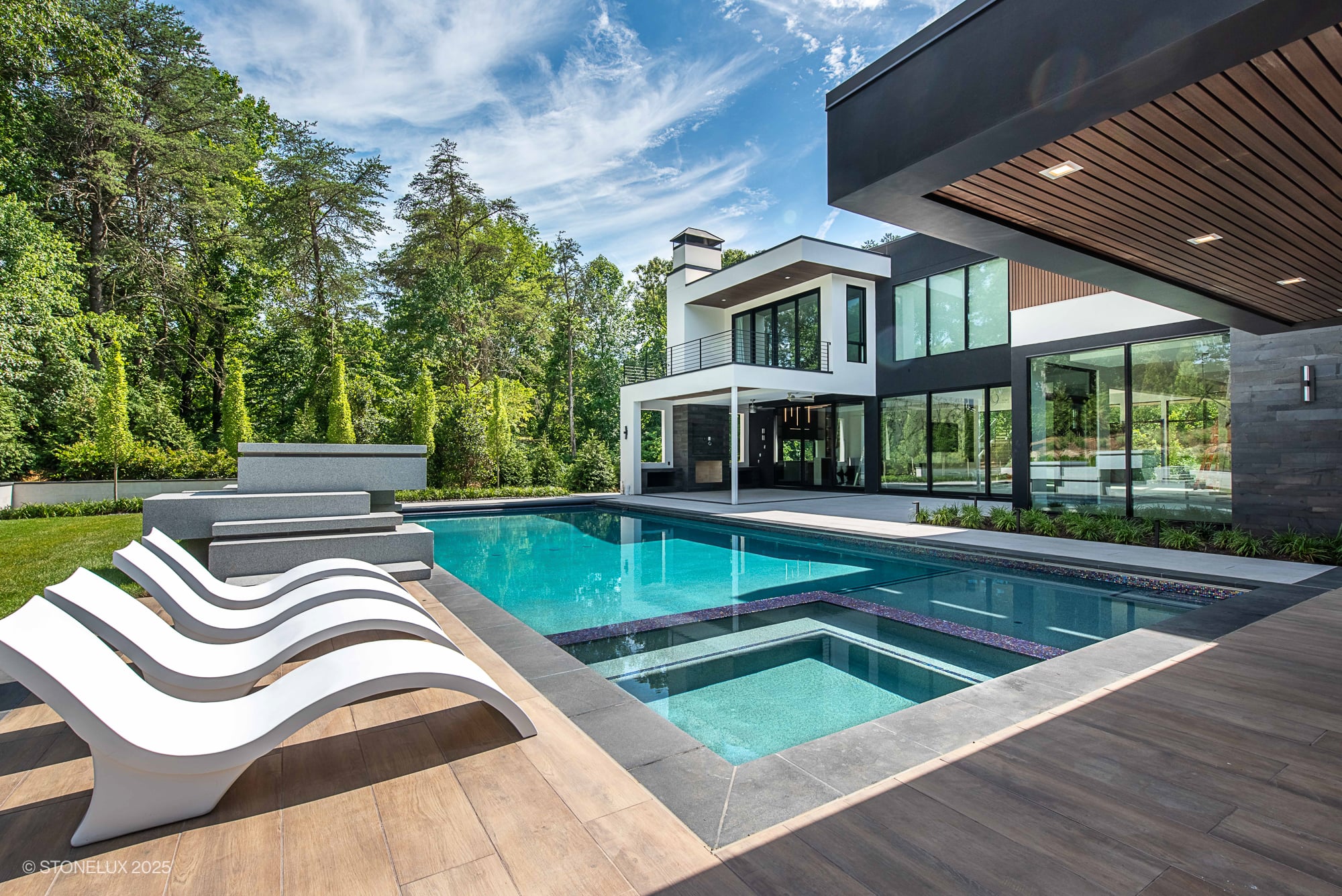 Large format porcelain pool deck with Black Basalt coping in a modern luxury pool project