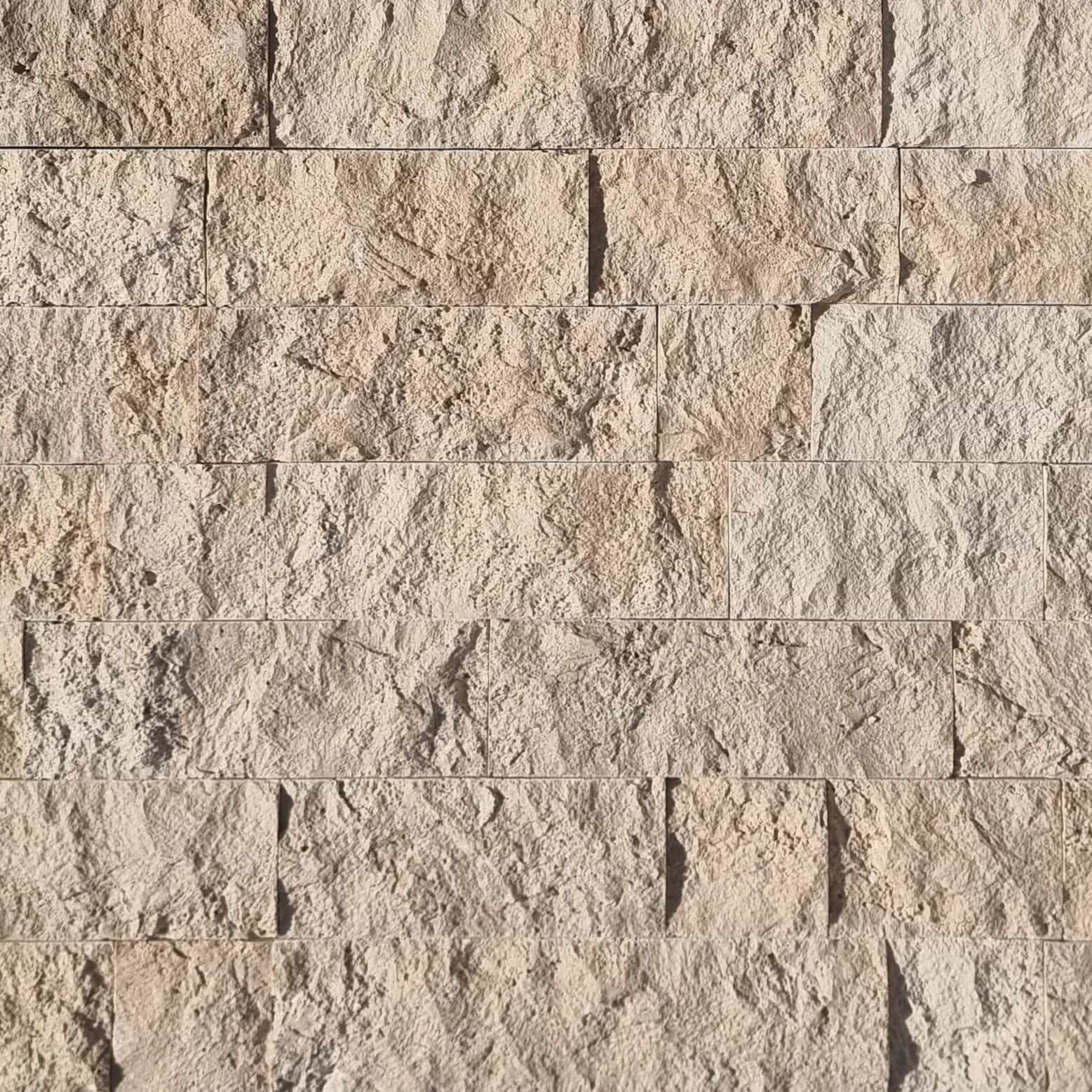 Close-up of Ivory Travertine Splitface Veneer showcasing its textured surface and natural beige tones. The 4" x Free Length travertine features subtle veining, ideal for adding rustic elegance to facades and accent walls. Perfect for stone veneer proje...