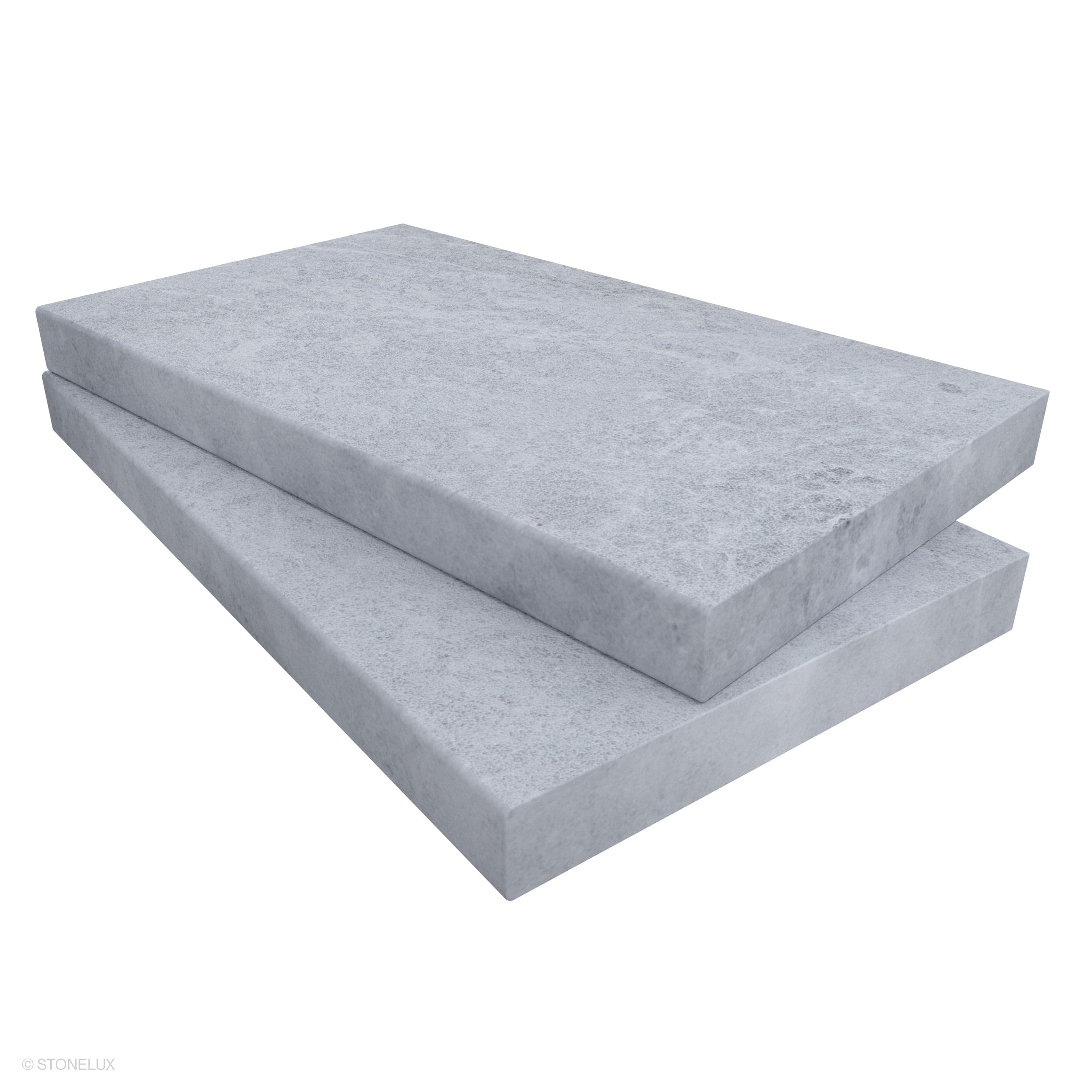 Close-up of STONELUX Tundra Grey Marble Sand Blasted 14x24x2 Eased Edge Coping. The marble features a sandblasted texture with subtle grey veining, showcasing an elegant and durable stone ideal for pool edges and wall caps.