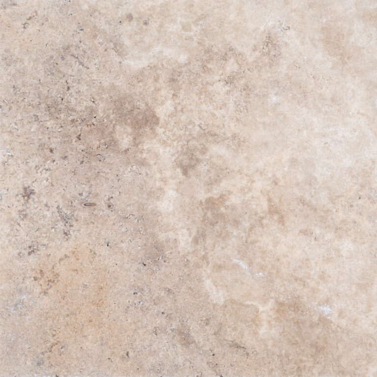 Close-up texture of a Philly Travertine surface with subtle variations in color ranging from light beige to patches of white and brown. Small grains and slight imperfections are visible.