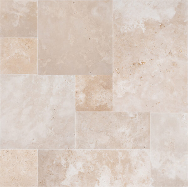 A pattern of various sized Ivory Travertine Tumbled French Pattern 3cm Pavers, showing rich textures and subtle color variations.
