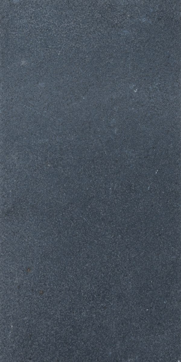 A close-up image of Black Basalt Tumbled+Brushed 12x24 3cm Paver surface with slight variations in shade and a few small specks visible.