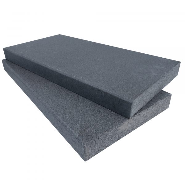 Two stacked Black Basalt Tumbled+Brushed 12"x24"x2" Eased Edge Copings on a neutral background, with smooth surfaces and slightly textured edges, showcasing shades of black.