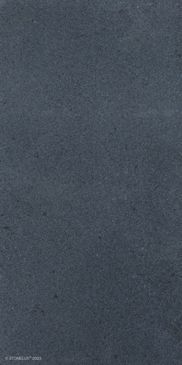 A close-up texture of a Black Basalt Tumbled+Brushed 8x16 3cm Paver surface with fine granular details.