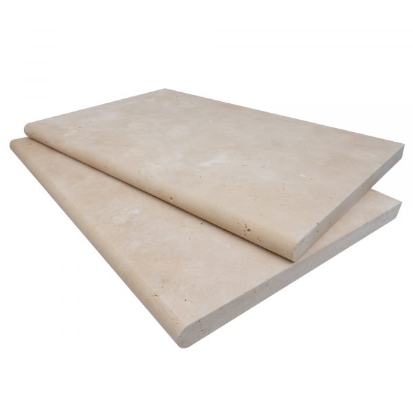 Two large, Ivory Travertine Tumbled 16"x24"x3CM Single Bullnose Copings stacked on top of each other, isolated on a white background.