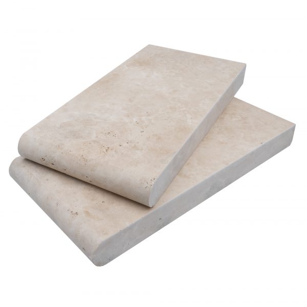 Two Ivory Travertine Tumbled 6"x12" rectangular single bullnose copings stacked on top of each other, isolated on a white background.