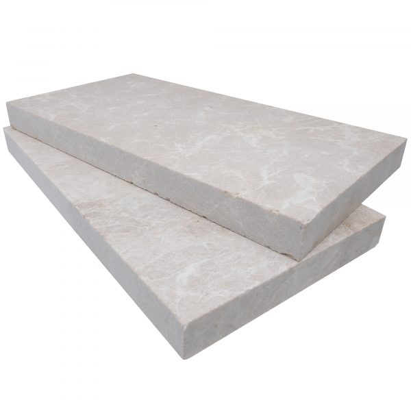 Two large, rectangular Pera Cream Marble Sand Blasted 12"x24"x2" Eased Edge Copings stacked on top of each other, isolated on a white background.