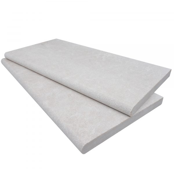 A rolled-up Pera Cream Marble Sand Blasted 12"x24"x3CM Single Bullnose Copings partially unrolled on a white background, highlighting its sand-blasted texture and color.